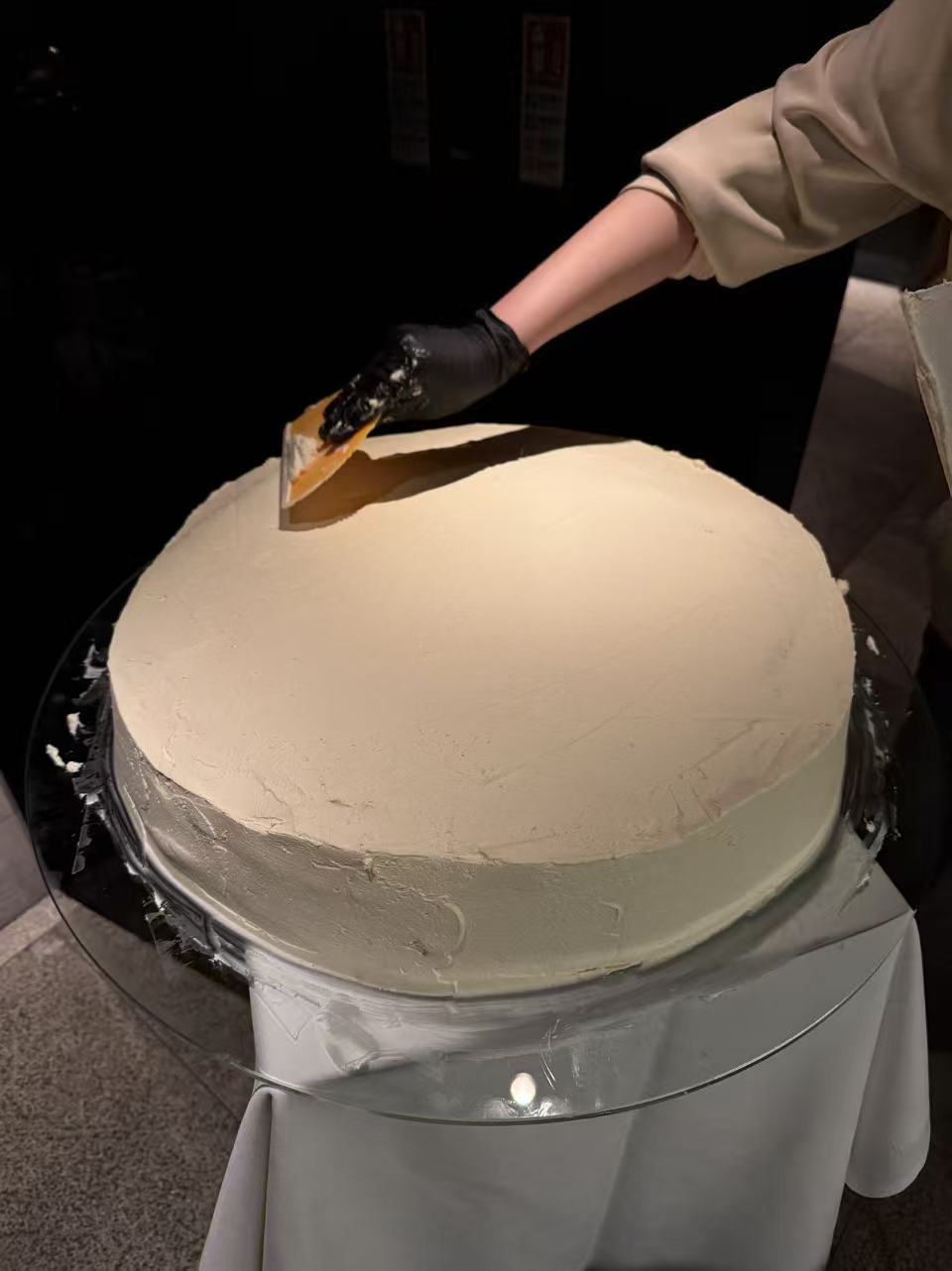 Large-format cake being finished by hand in the studio